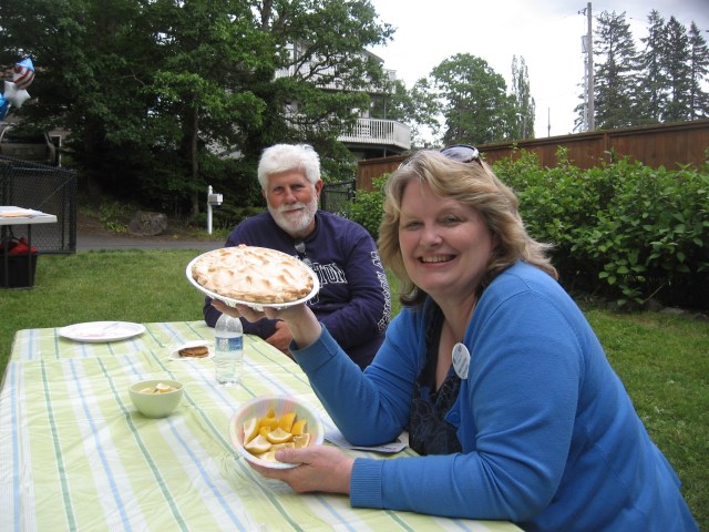 Marianne Scott Lincoln offers a pie for sale, as Bill Harringon looks on.